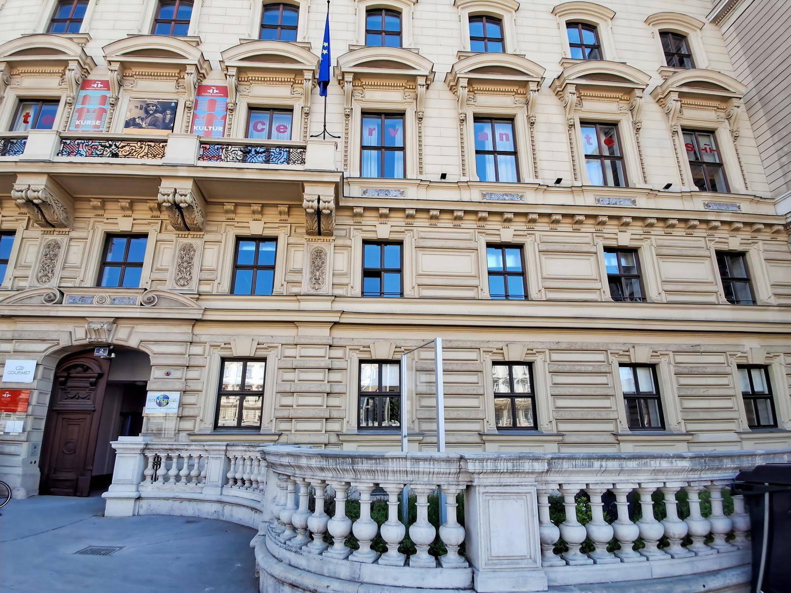 Prächtige Fassade eines klassischen Gebäudes mit vielen Fenstern, kunstvollen Verzierungen und einer Steintreppe.
