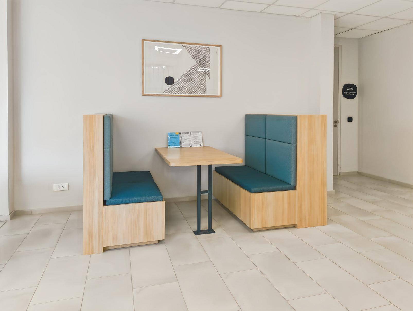 Gemütlicher Sitzbereich mit zwei gepolsterten Bänken und einem kleinen Tisch, ideal für kurze Pausen.