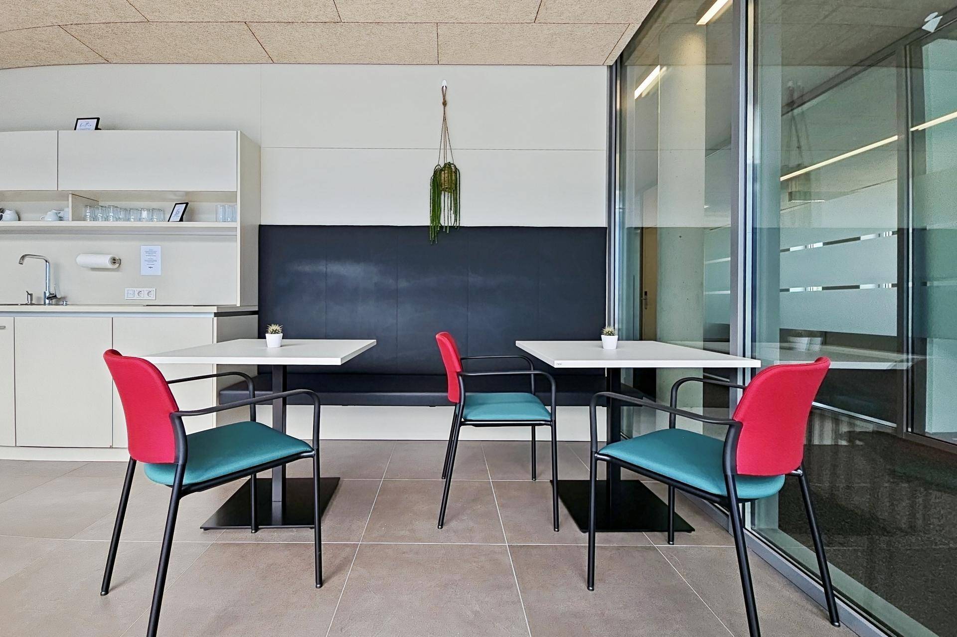 Moderne Küchenzeile mit Sitzbereich, weißen Schränken und großen Fenstern für viel Tageslicht.