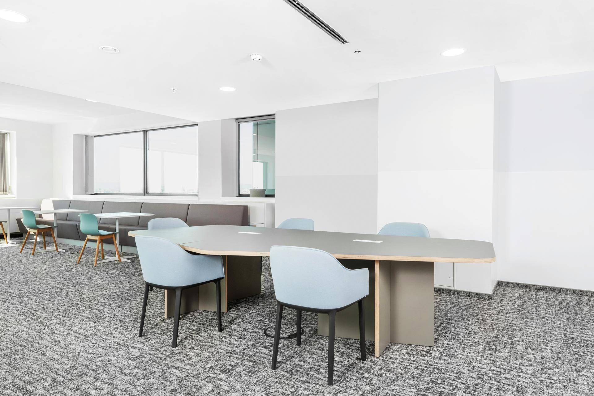 Geräumiger Lounge-Bereich mit einem großen Besprechungstisch und bequemen Sitzgelegenheiten für informelle Treffen.