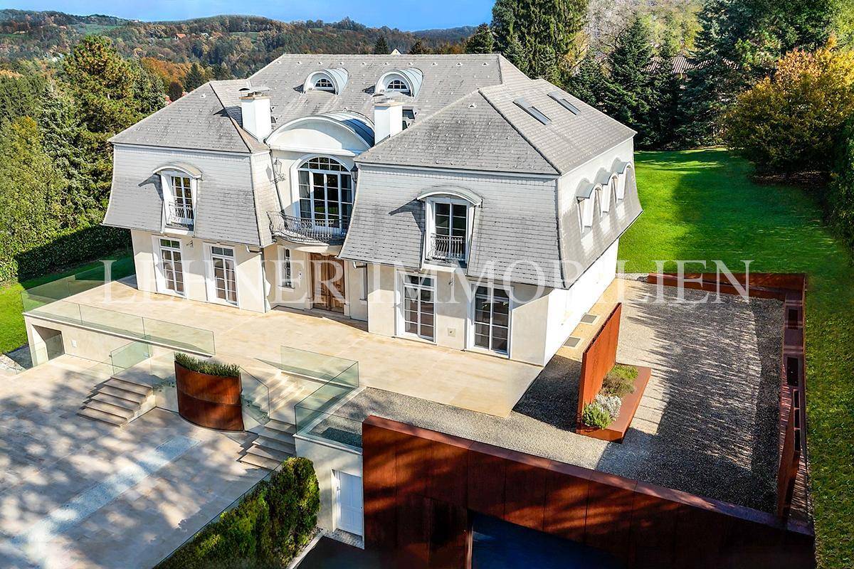 Luftaufnahme der luxuriösen Villa mit weitläufigem Grundstück, Poolbereich und gepflegtem Garten.