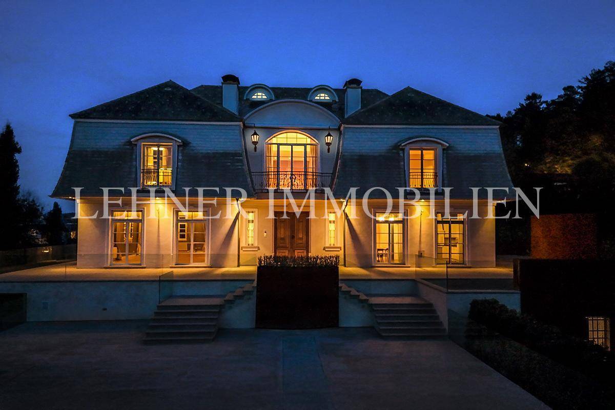 Die beleuchtete Fassade der Villa bei Nacht, die ihre architektonische Schönheit hervorhebt.