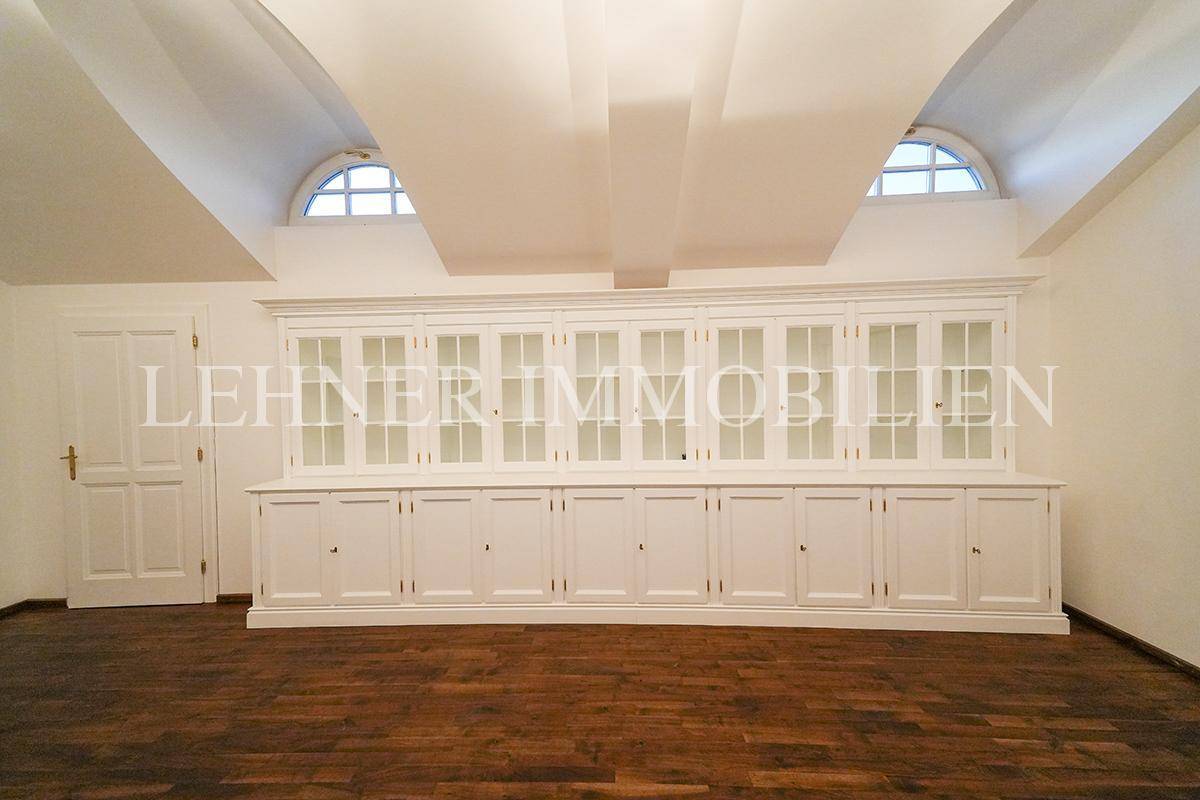 Geräumiger Dachbodenraum mit großen Einbauschränken und gewölbter Decke.