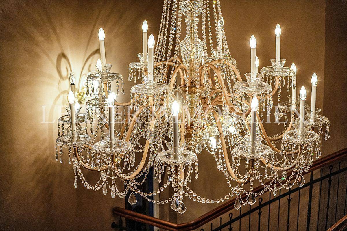 Detailansicht des opulenten Kristallkronleuchters, der das Treppenhaus prunkvoll beleuchtet.