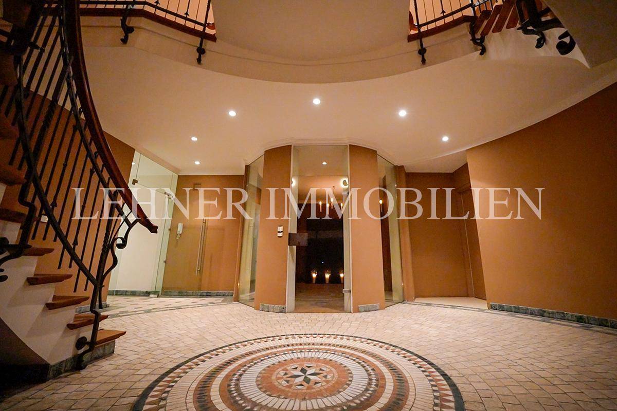 Geräumiger Eingangsbereich mit Mosaikboden und Blick auf den weiteren Flur.