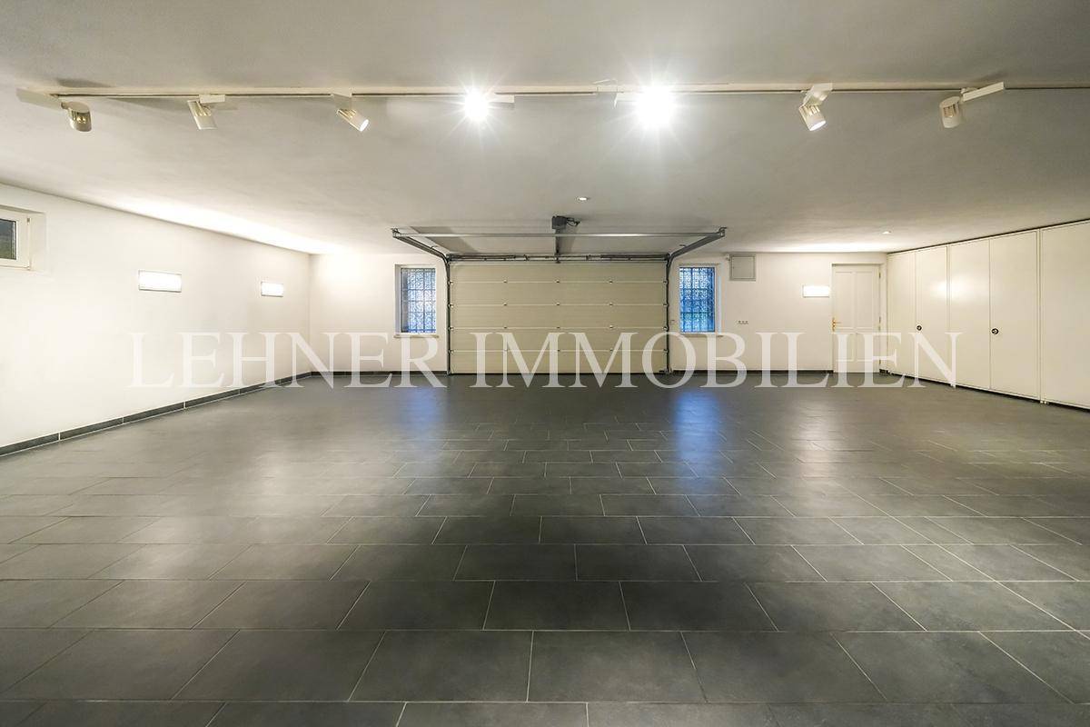 Geräumige Tiefgarage mit Fliesenboden, Rolltor und viel Platz für Fahrzeuge.