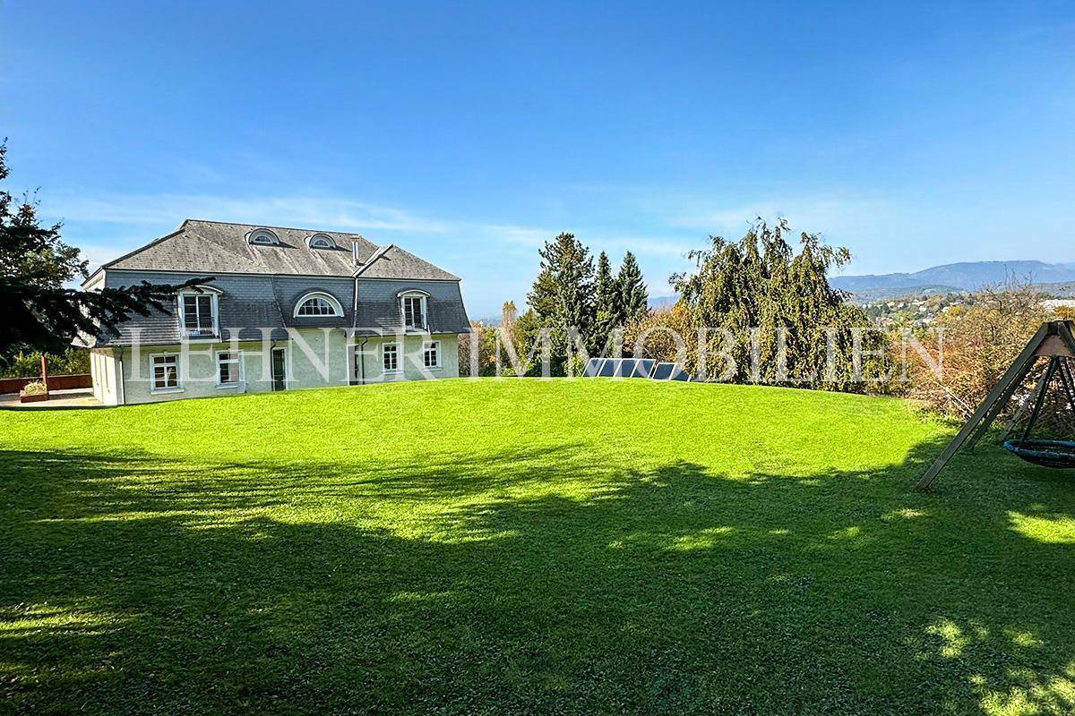 Weitläufiger Gartenbereich der Villa mit Spielplatz und Blick auf die umliegende Landschaft.