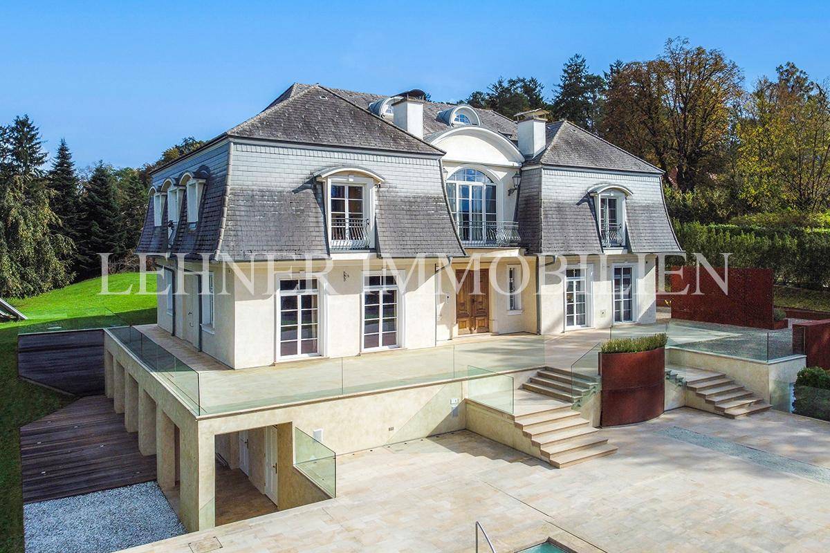 Eindrucksvolle Fassade der Villa mit großzügiger Terrasse und eleganten Fenstern.