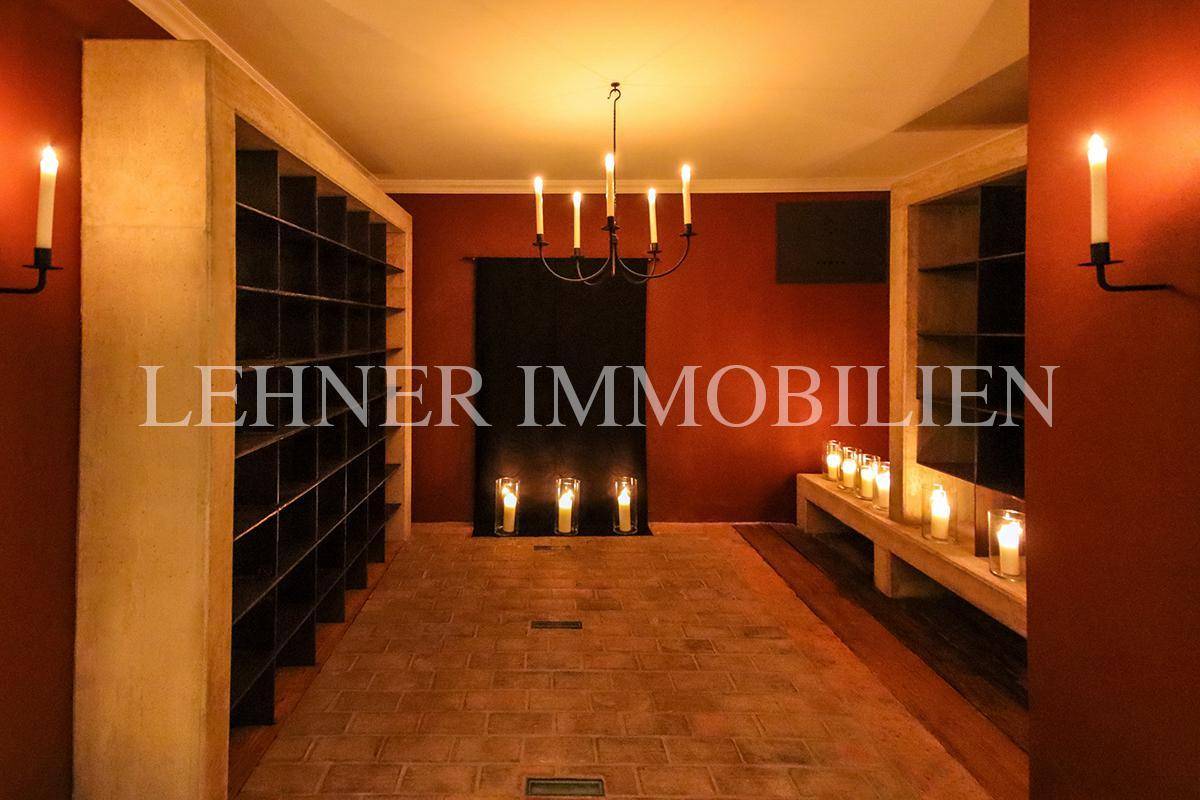 Stimmungsvoller Weinkeller mit Ziegelboden, Regalen und Kerzenbeleuchtung.