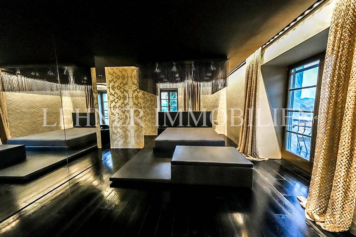 Luxuriöses Schlafzimmer mit dunklem Holzfußboden, minimalistischem Design und Zugang zum Balkon.