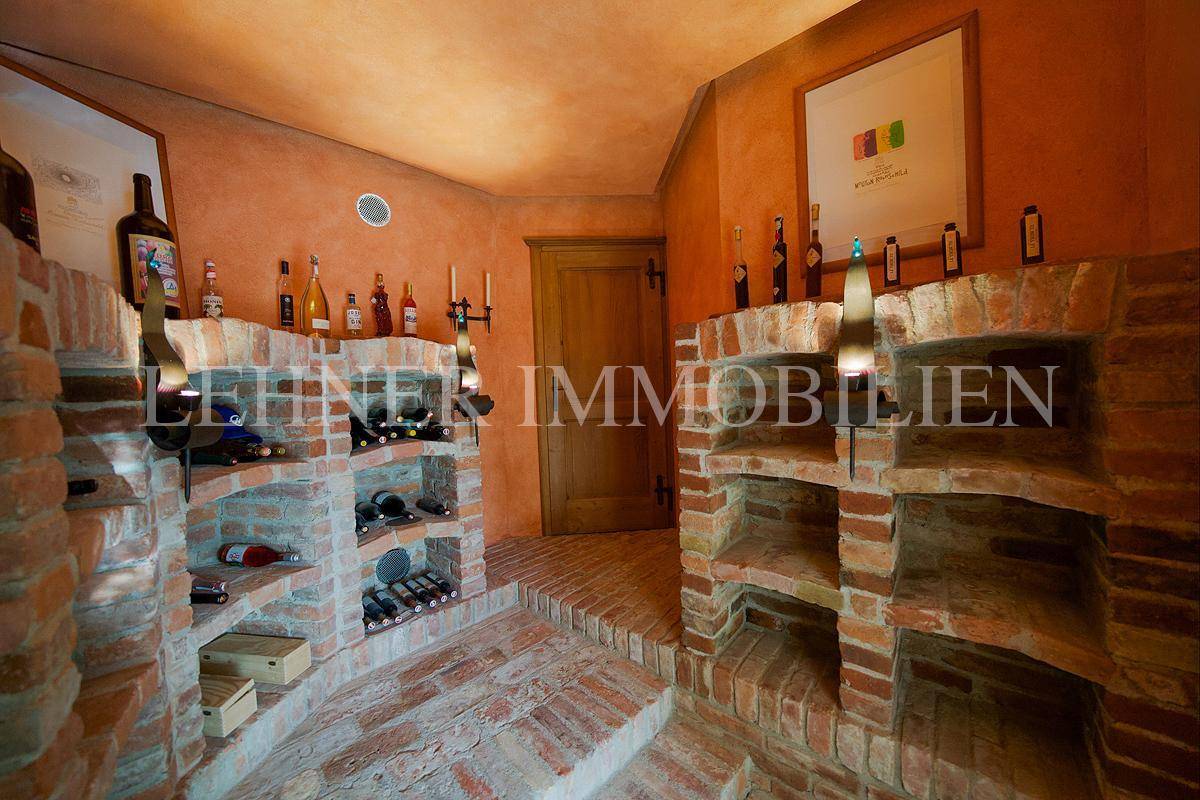 Rustikaler Weinkeller mit Ziegelregalen und Flaschenlagerung, ideal für Weinliebhaber.