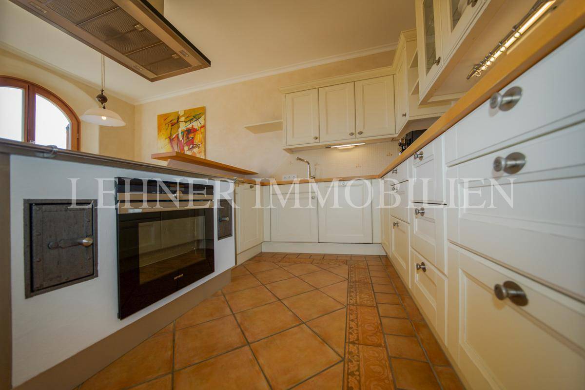 Detailansicht der Einbauküche mit integriertem Backofen und Terrakottafliesen.