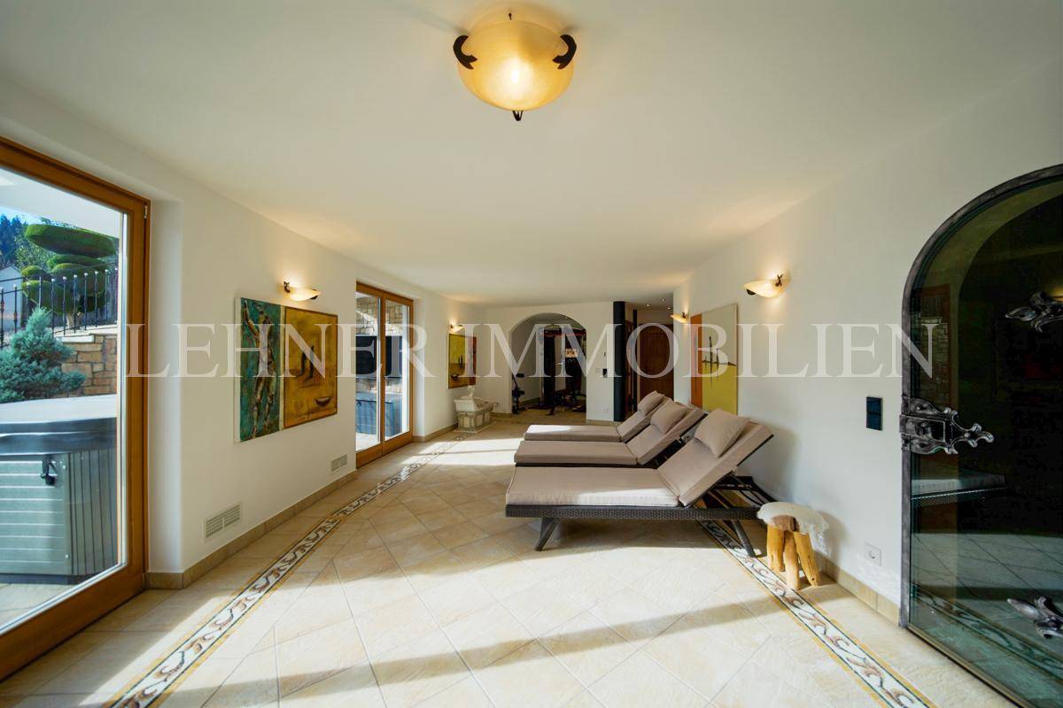 Entspannungsbereich mit Liegen, Fliesenboden und Zugang zur Außenterrasse.