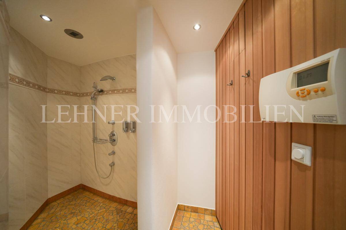 Duschbereich mit Fliesen und Saunasteuerung im Wellnessbereich.