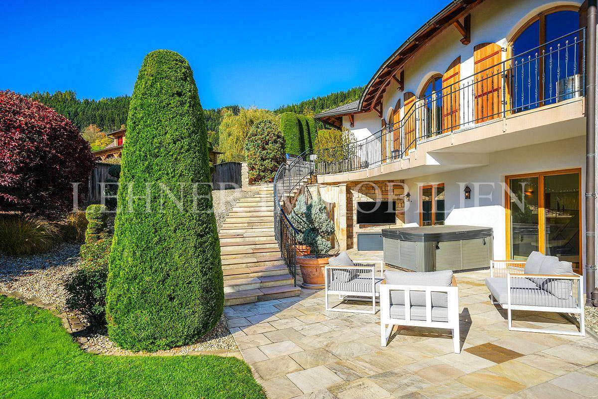 Sonniger Terrassenbereich mit modernen Sitzmöbeln und gepflegter Gartenanlage.