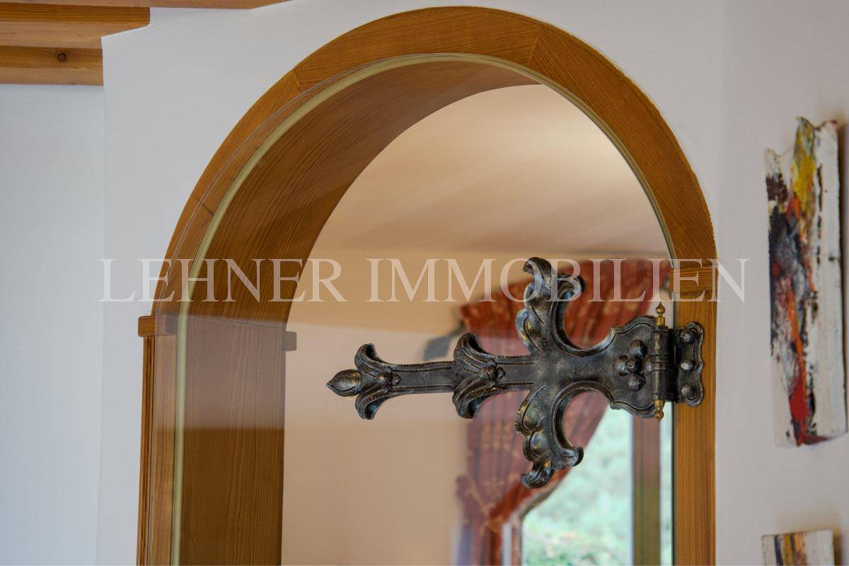 Detailansicht eines Holzbogens mit dekorativem schmiedeeisernem Beschlag.