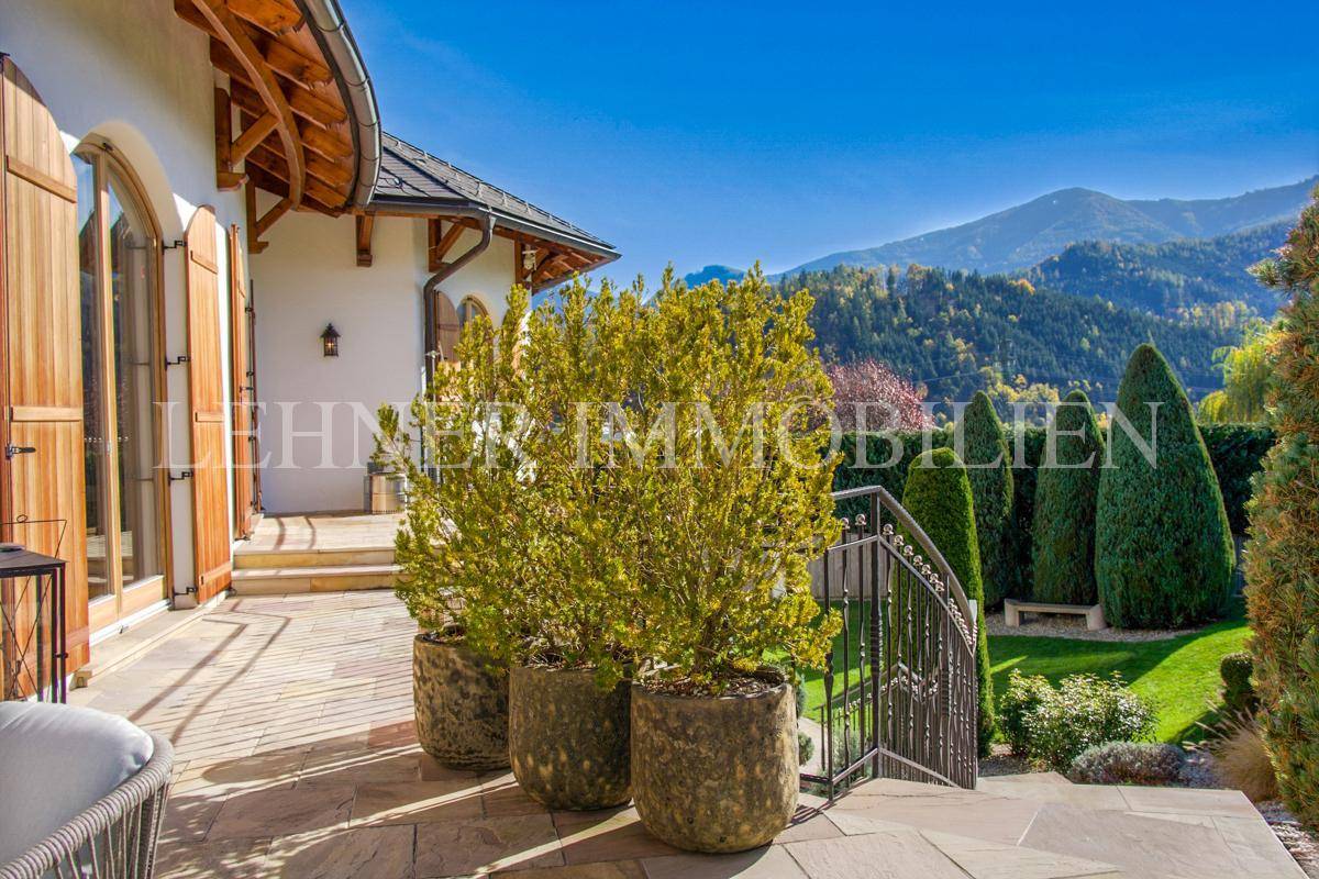 Sonniger Terrassenbereich mit Topfpflanzen und Blick auf die umliegende Berglandschaft.