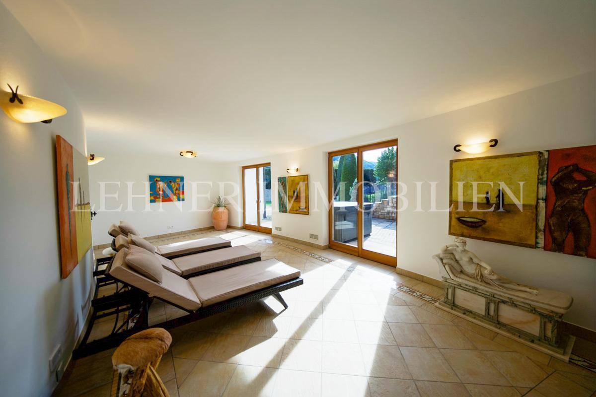 Entspannungsbereich mit Liegen, Fliesenboden und Zugang zur Außenterrasse.