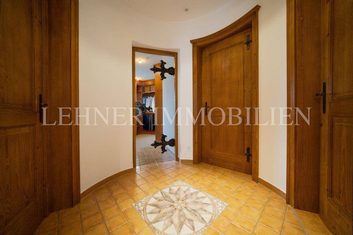 Flur mit Terrakottafliesen und dekorativem Sternmuster, umgeben von Holztüren.