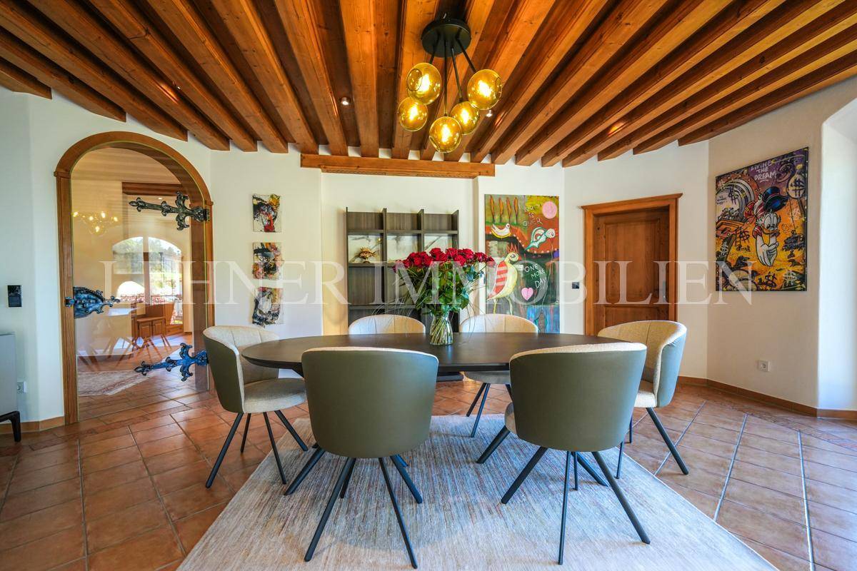 Essbereich mit modernem Esstisch, bequemen Stühlen und Kunstwerken an den Wänden.