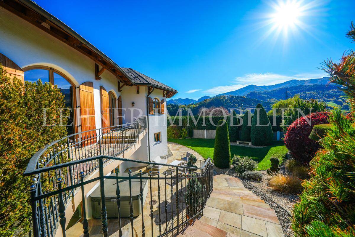 Sonniger Terrassenbereich mit Blick auf die Berge und den gepflegten Garten.