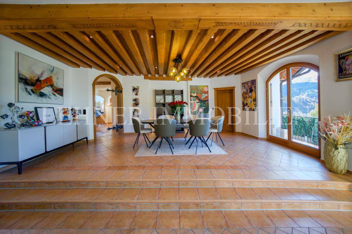 Geräumiger Essbereich mit Holzbalkendecke, Terrakottafliesen und Kunstwerken an den Wänden.