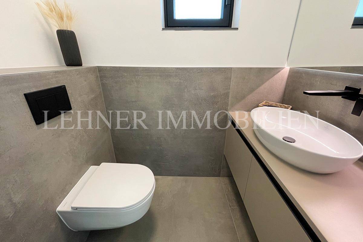 Modernes Gäste-WC mit Wand-WC, Aufsatzwaschbecken und Fenster für Tageslicht.