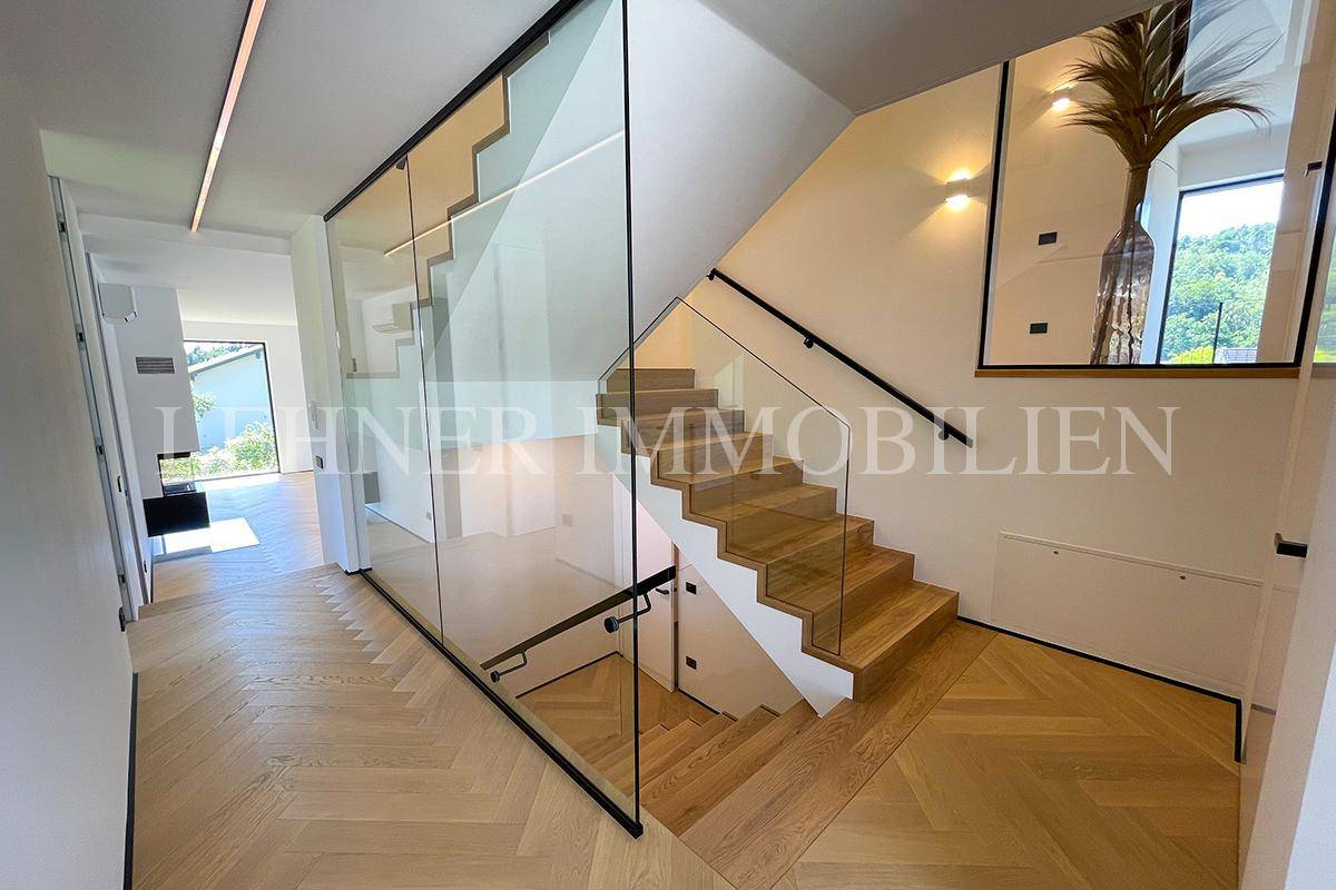 Elegante Holztreppe mit Glasgeländer und modernem Design, die die Etagen verbindet.