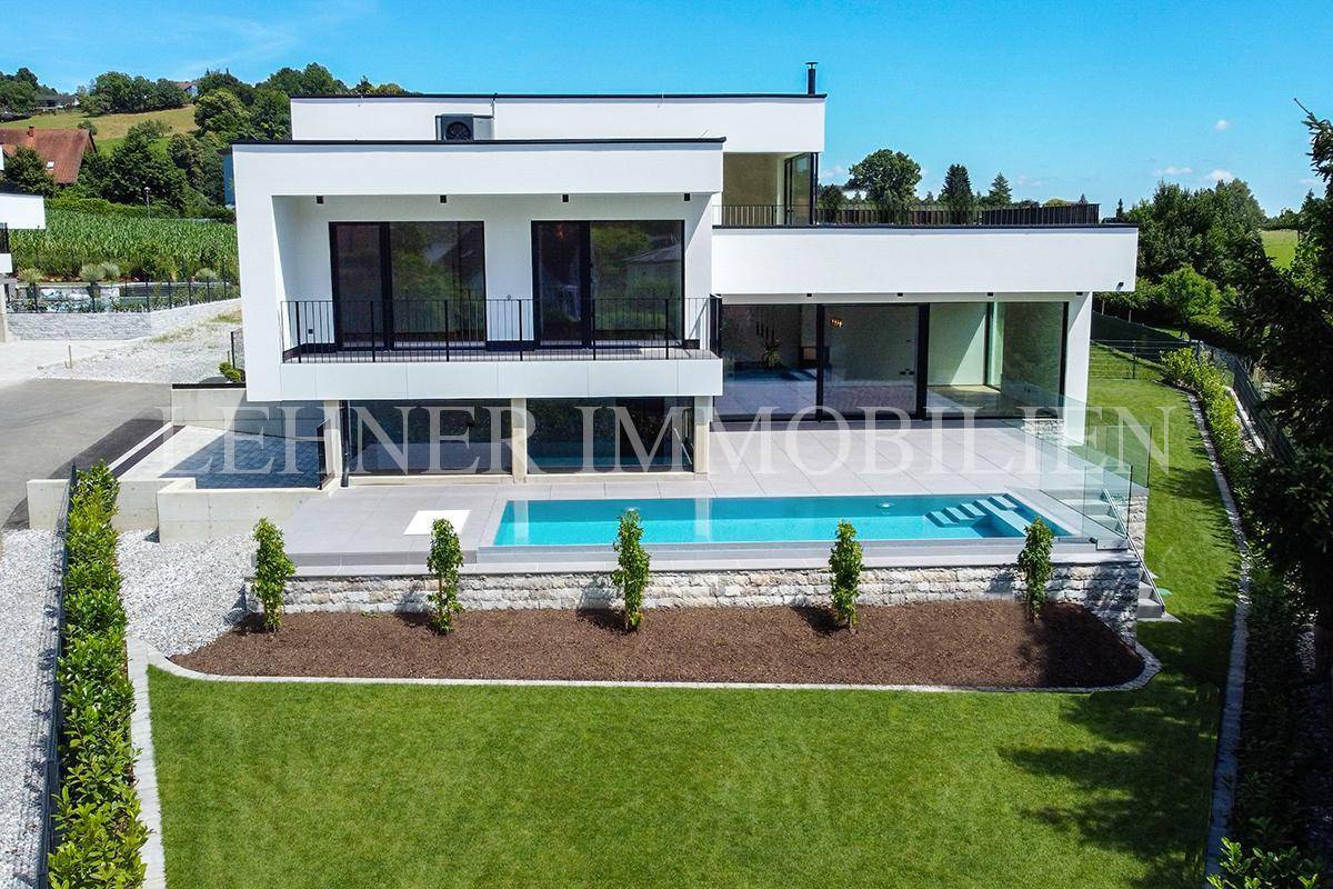 Weitläufiger Gartenbereich mit modernem Pool und der eleganten Architektur der Villa.