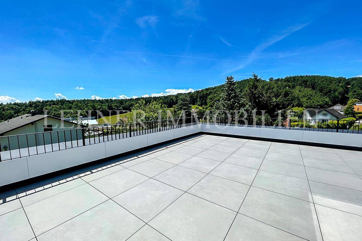 Weitläufige Dachterrasse mit Fliesenboden und Panoramablick auf die umliegende Landschaft.