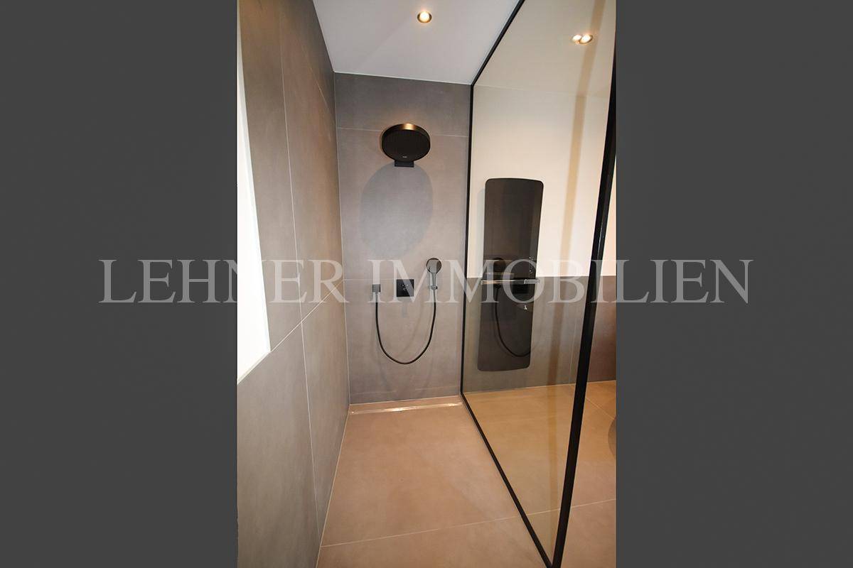 Moderne begehbare Dusche mit Regenduschkopf und minimalistischem Design.
