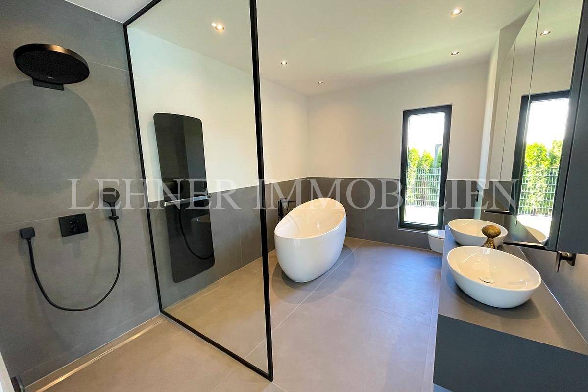 Modernes Badezimmer mit freistehender Badewanne, begehbarer Dusche und Doppelwaschbecken.
