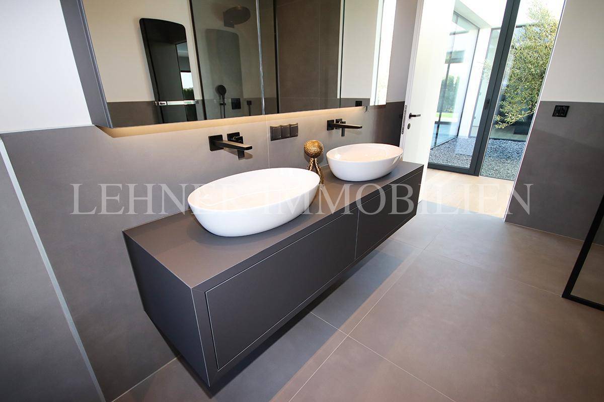 Elegantes Badezimmer mit Doppelwaschbecken, großem Spiegel und moderner Ausstattung.