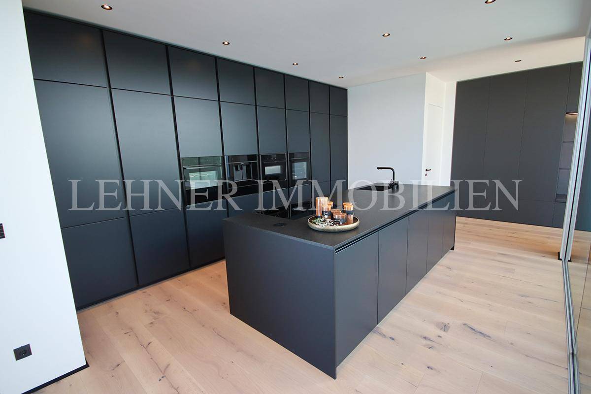 Elegante schwarze Einbauküche mit integrierten Geräten und minimalistischem Design.