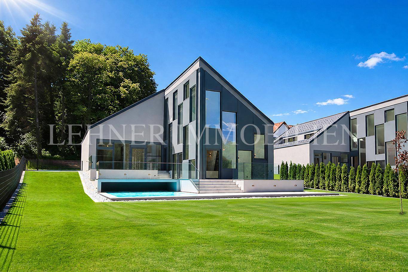 Moderne Villa bei Tag mit großem Garten, Pool und weitläufiger Grünfläche.