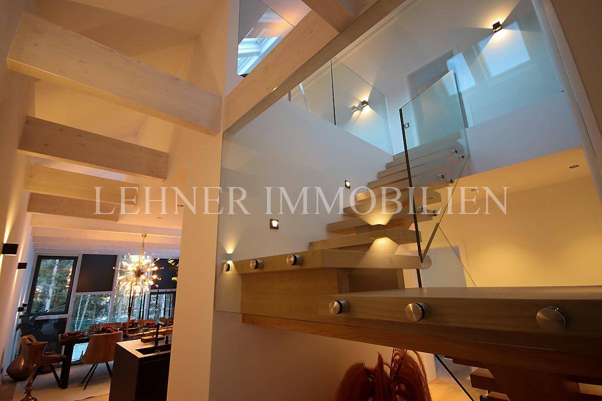 Moderne Holztreppe mit Glasbrüstung und stilvoller Beleuchtung, verbindet die Ebenen.