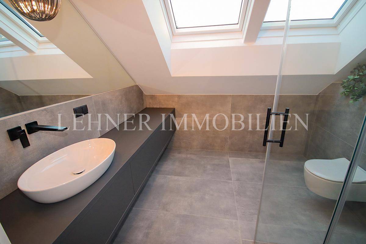 Modernes Badezimmer im Dachgeschoss mit Schrägdach, Dusche und Dachfenstern.