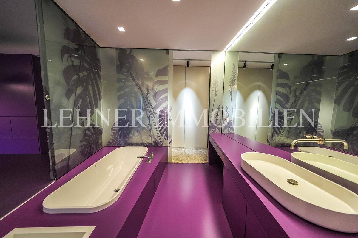 Stilvolles Badezimmer mit lila Boden, Doppelwaschbecken und integrierter Badewanne.