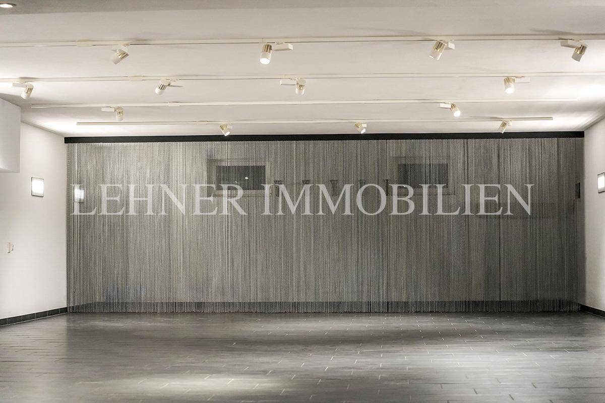 Geräumige Tiefgarage mit Fliesenboden und dekorativem Metallvorhang an der Wand.