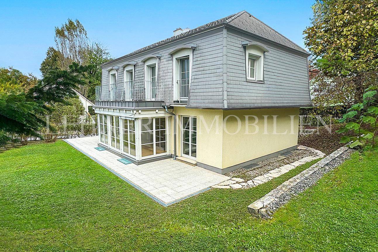 Seitenansicht des Hauses mit Wintergarten, Terrasse und Gartenbereich.