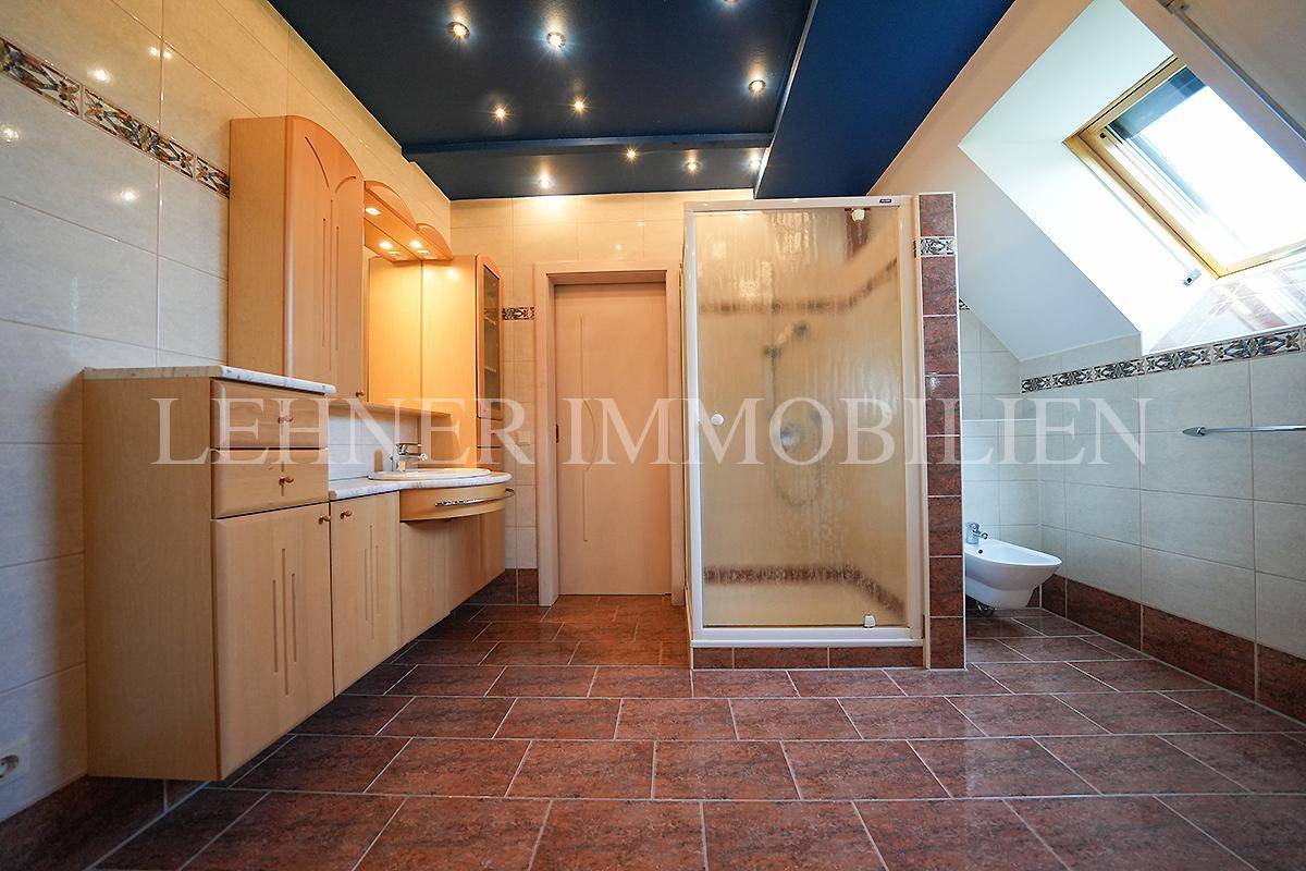 Modernes Badezimmer im Dachgeschoss mit Badewanne, Dusche, Bidet und Dachfenster.