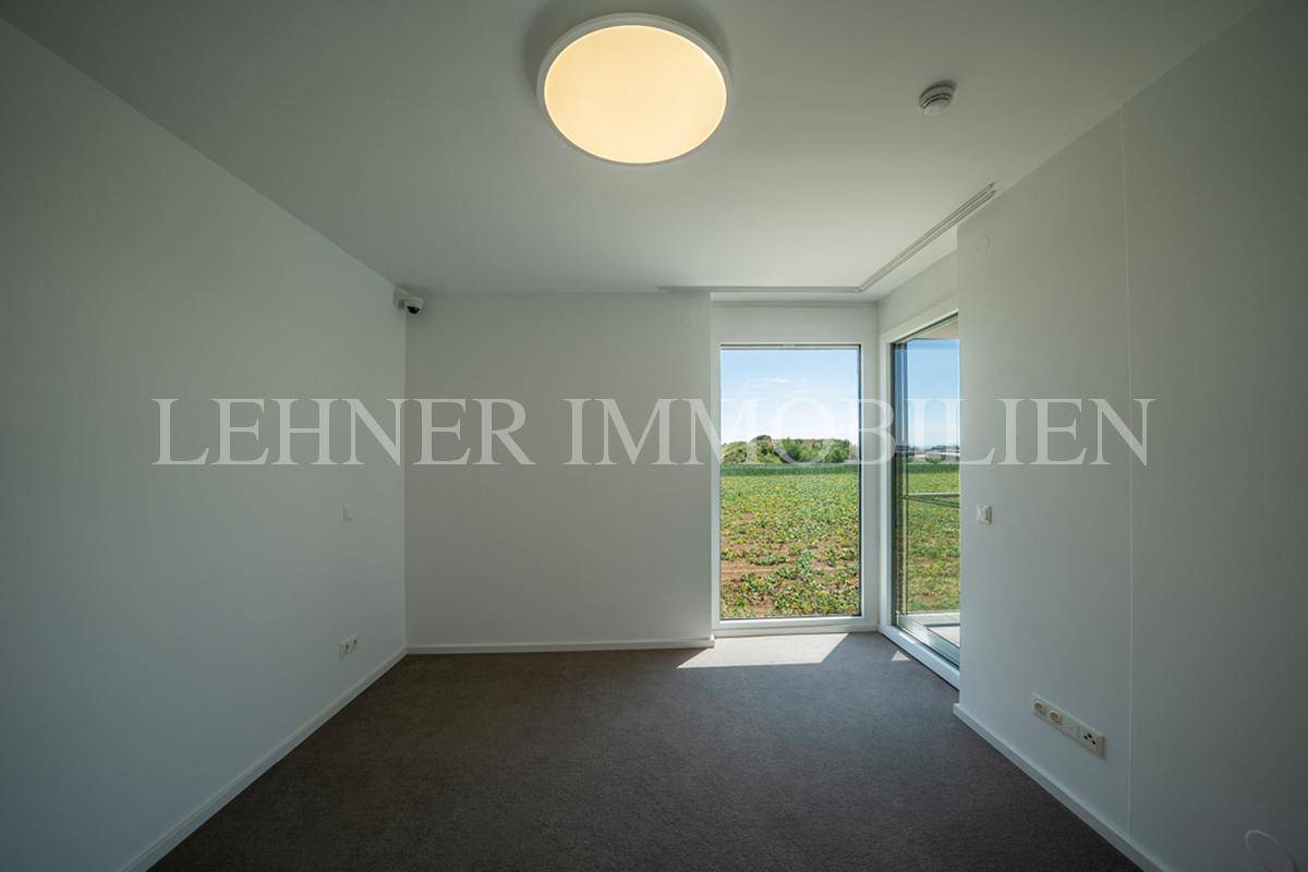 Schlafzimmer mit Teppichboden und bodentiefen Fenstern, die eine weite Aussicht ermöglichen.