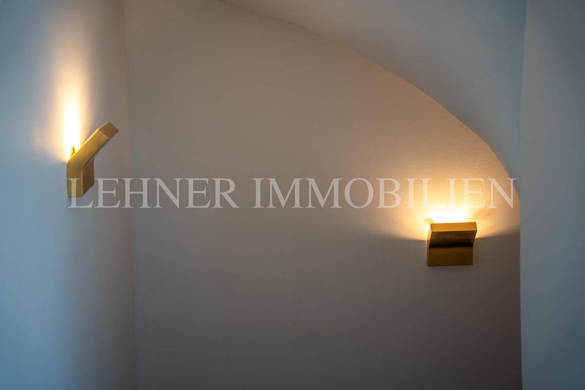 Detailaufnahme von modernen Wandleuchten, die eine warme und indirekte Beleuchtung bieten.