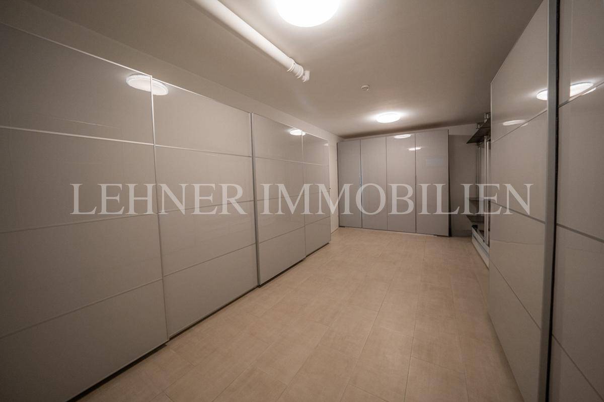 Moderner begehbarer Kleiderschrank mit grauen Schiebetüren und praktischem Fliesenboden.