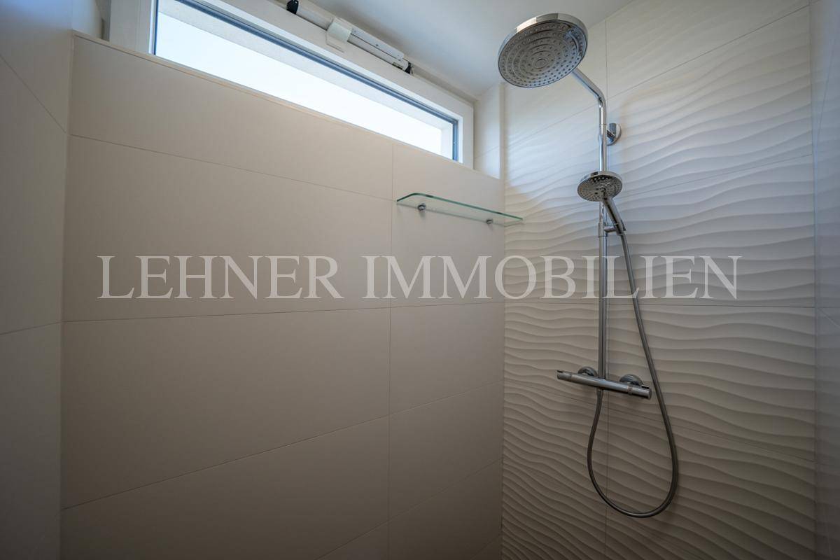 Duschbereich mit Regendusche und Fenster für natürliche Belüftung und Helligkeit.