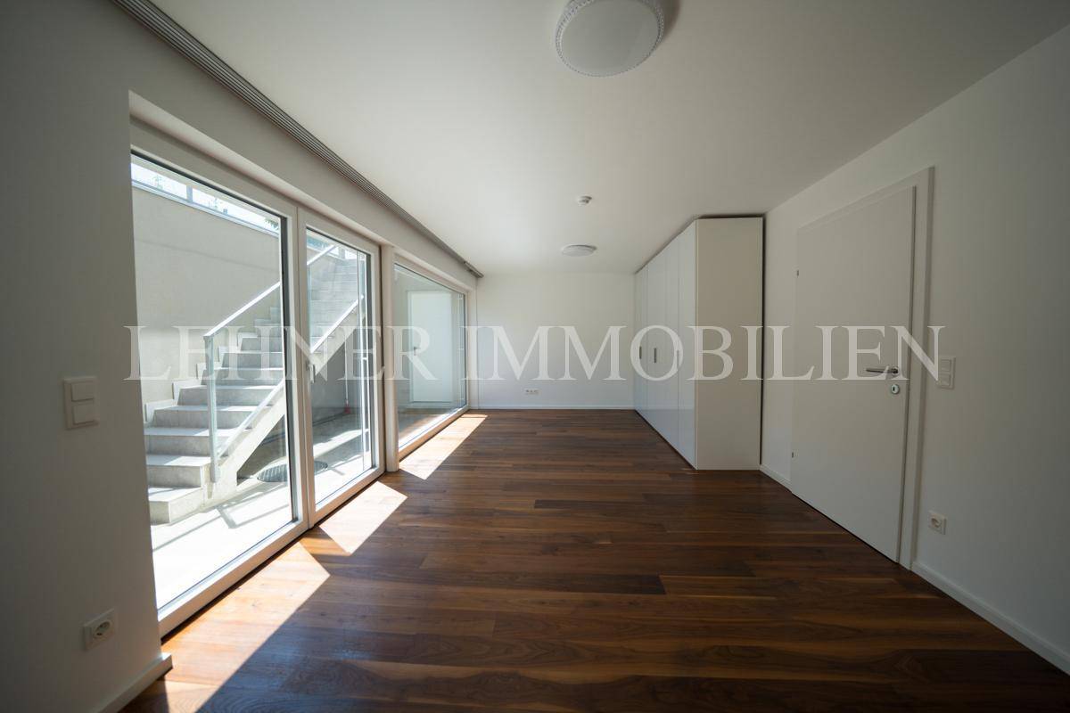 Heller Raum mit Holzfußboden, großen Fenstern und Einbauschränken, vielseitig nutzbar.
