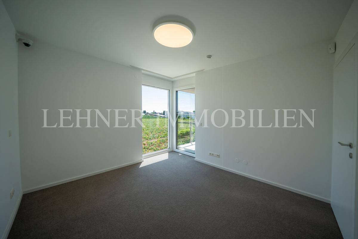 Helles Schlafzimmer mit großen Fenstern und Blick ins Grüne, bietet viel Tageslicht.