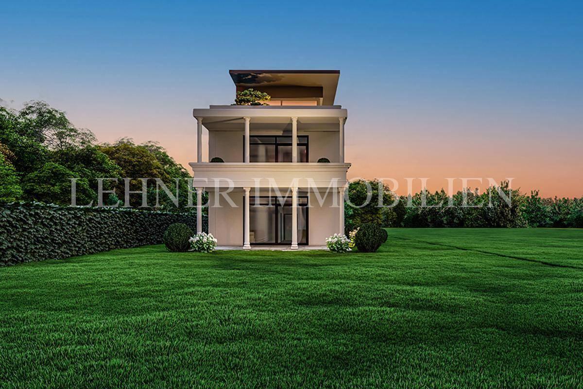Rückansicht einer modernen Villa mit gepflegtem Rasen und Hecke bei Sonnenuntergang.
