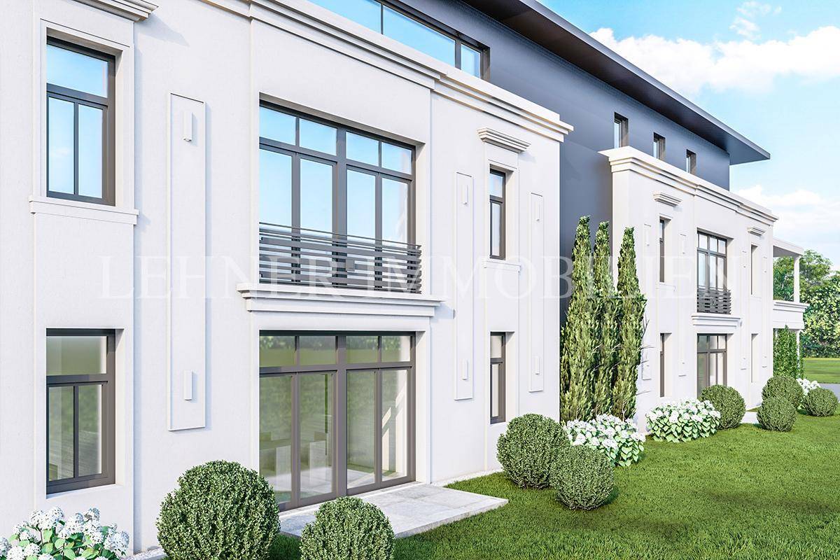 Detailansicht der modernen Fassade einer Villa mit großen Fenstern und gepflegten Büschen.