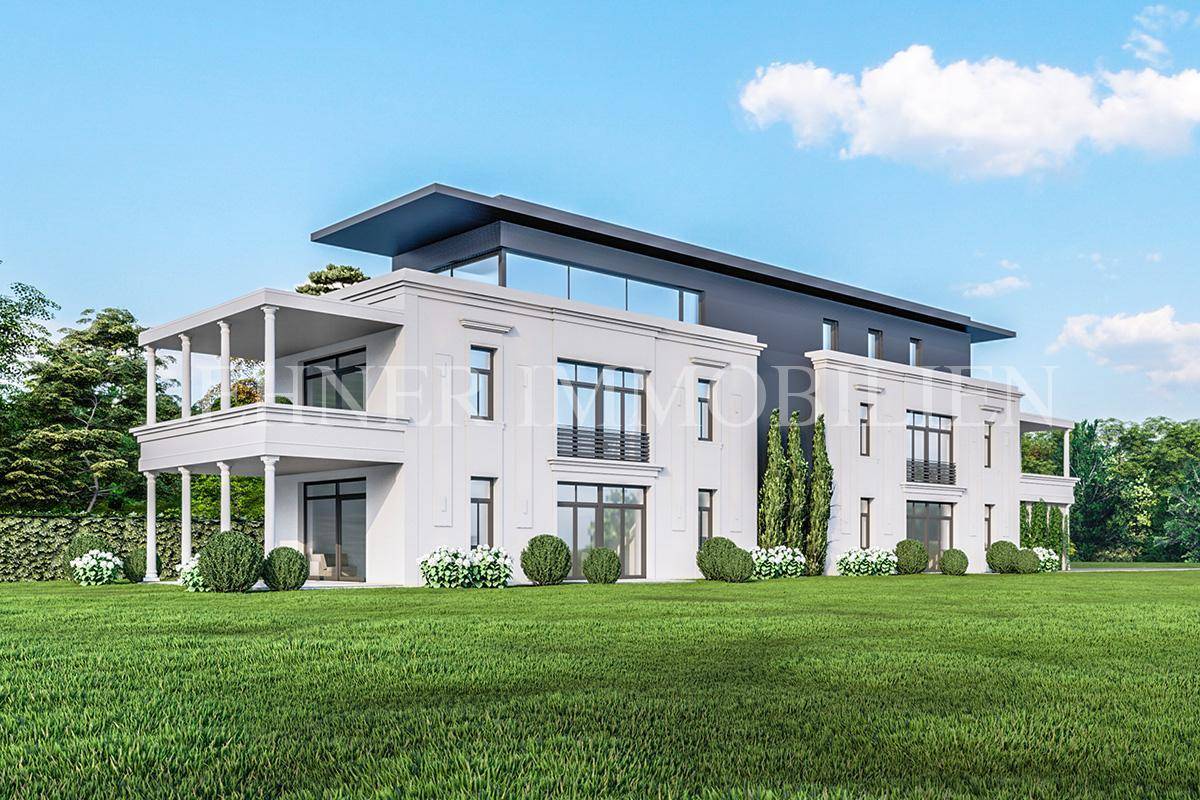 Eine elegante Villa mit weitläufigem Rasen und klassisch-moderner Architektur unter blauem Himmel.